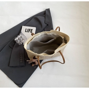 Internal structure of large tote bag showing zipper pockets and spacious cream PU interior