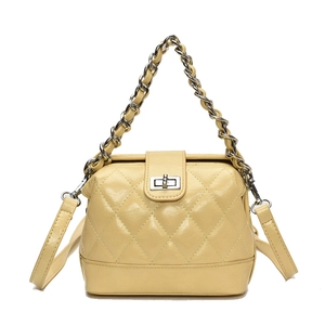 Pale yellow quilted handbag with silver chain handle and metallic turn-lock closure