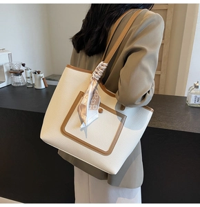 Detailed shot of white lychee leather tote bag with silk scarf on handle for daily use