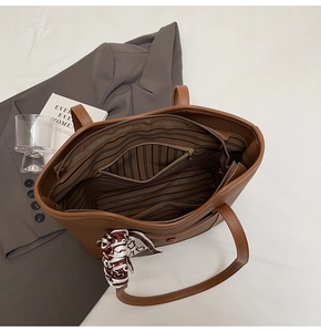 Close-up of caramel tote bag interior with striped lining and decorative silk scarf detail
