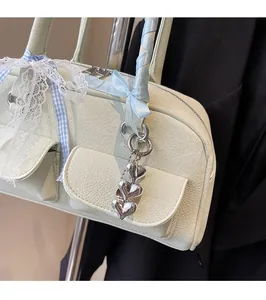Detail view of mint green pebble leather bag with satin bow and silver heart pendant