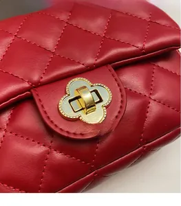 Close-up of red quilted leather bag featuring a gold floral-shaped metal clasp