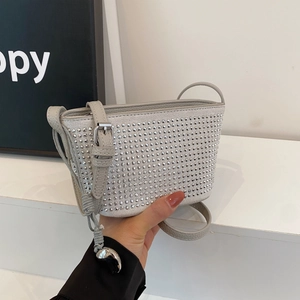 Close-up of silver studs on light gray lychee pattern leather of this crossbody bag