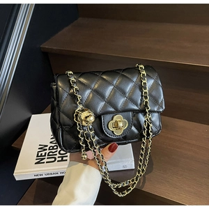Detail of black quilted leather bag with gold flower twist lock and chain strap