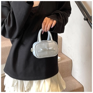 Close-up of a light blue mini bag with a 3D bow and elegant matte leather texture