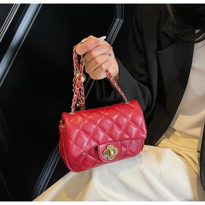 Detailed close-up of a red quilted chain bag featuring a gold floral twist lock