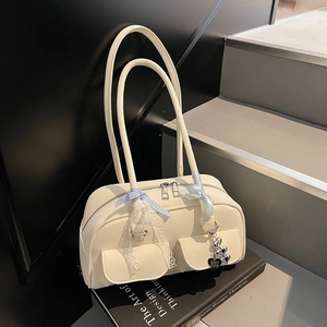 Detail of off-white leather shoulder bag with blue ribbon bow and silver heart pendants