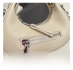 Detailed macro view of white lychee leather texture and silver zipper hardware