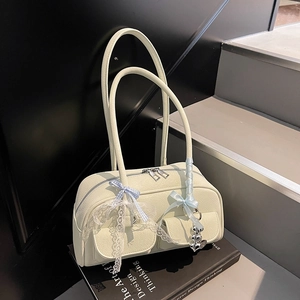 Close-up of lychee grain PU leather cream Boston bag with lace and bow details