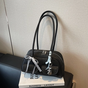 Black large capacity shoulder bag with lace bows and heart pendants on white books