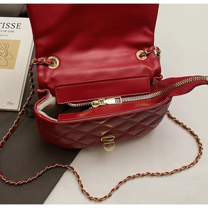 Detail view of red quilted leather crossbody bag with gold chain strap and interior space