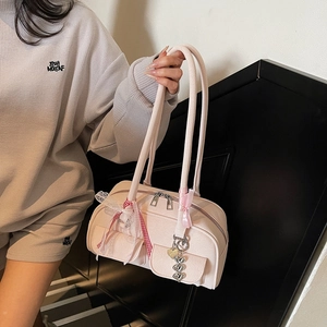 Pink PU leather shoulder bag with decorative ribbons and heart pendant detail