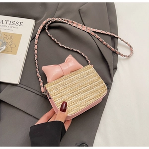 Détail du nœud rose et texture paille du sac à bandoulière pour enfants avec chaîne