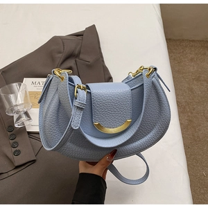 Detail of light blue lychee pattern leather shoulder bag with gold crescent hardware