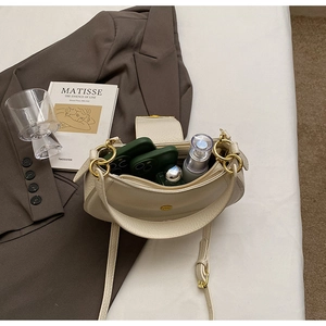 Interior view of off-white crescent saddle bag with spacious compartments and zipper layer