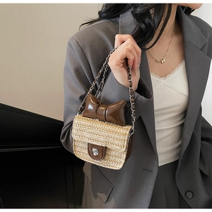 Gros plan du mini sac en paille avec nœud en cuir marron et chaîne argentée sur modèle