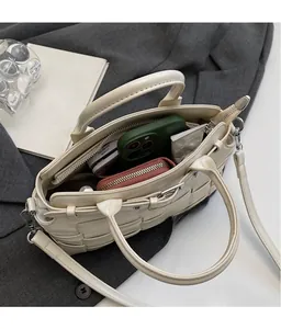 Top view of spacious woven handbag interior showing a smartphone and wallet storage