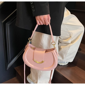 Detail of light pink saddle bag featuring lychee grain texture and gold metal buckle