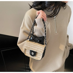Détail du sac en paille tressé main pour fille avec nœud noir et fermoir fleur argenté