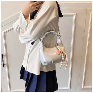 Detail of glossy pleated cloud handle bag with heart charm and woven rope decor
