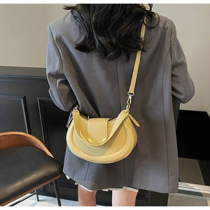 Bright yellow crescent crossbody bag in pebbled leather with gold metal trim detail