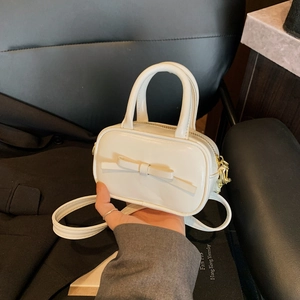 Creamy white mini crossbody bag with a bow detail and gold hardware for girls