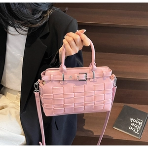 Detail of pink hand-woven leather handbag with metal buckle and crossbody strap