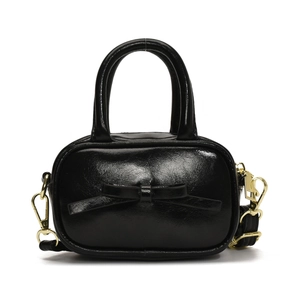 Glossy black mini bag with leather bow and gold hardware for kids, shown on white background
