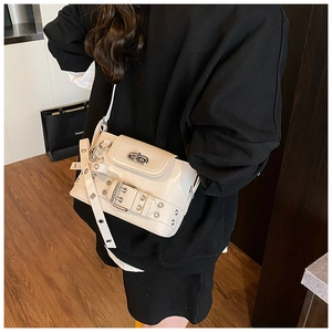 Détail d'un petit sac bandoulière blanc crème avec boucle de verrouillage rotative argentée