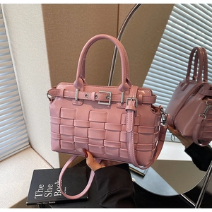 Detail of pink woven leather texture and silver buckle on a stylish crossbody bag