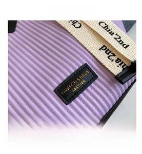 Détail du sac cabas violet montrant la texture ondulée verticale et l'étiquette en cuir