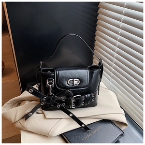 Détail du sac bandoulière en cuir verni noir avec sangles à boucle et fermoir rotatif en métal