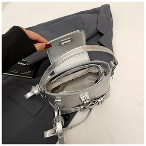 Détail du sac argenté en PU métallisé avec sangles à boucles et poche zippée interne