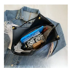 Vue intérieure montrant la grande capacité du sac fourre-tout noir avec objets du quotidien