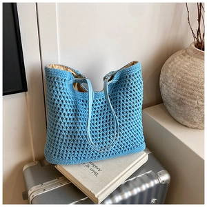 Macro shot of light blue crochet hollow tote bag with leather strap and linen lining