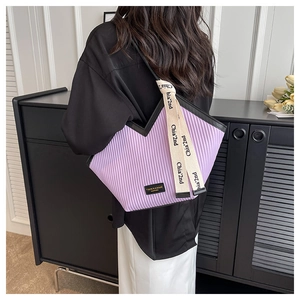 Détail du cabas plissé violet avec passepoil noir et sangles décoratives de style chic