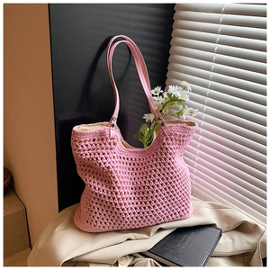 Close-up of pink crochet tote bag with honeycomb knit texture and leather handle details