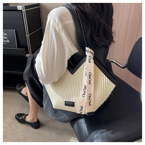 Vue détaillée du sac cabas plissé crème avec bordures en cuir noir et bandoulière chic