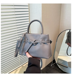 Close-up of gray litchi texture leather tote bag featuring metal buckle and top handle