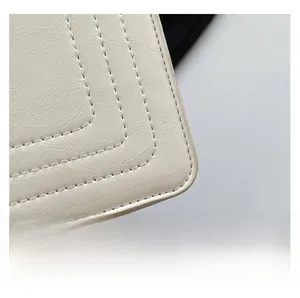 Detail of ivory oil wax leather texture and stitching on a minimalist crossbody bag