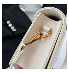 Detail of white crocodile embossed leather handbag with vintage gold metal hardware buckle