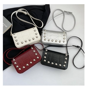 Detail of square crossbody bags featuring geometric stitching and silver rivet accents