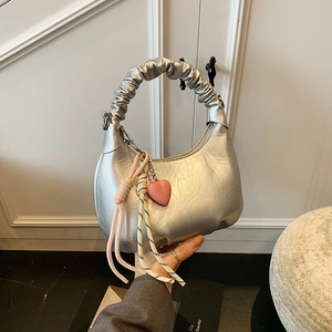 Silver metallic crescent handbag with ruffled handle and pink heart pendant