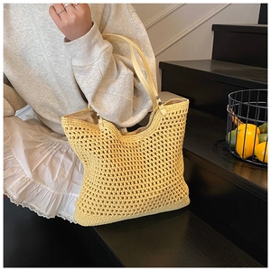 Detail of hollow woven shoulder bag with leather handles and summer lemon scene