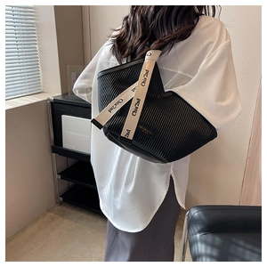 Détail du sac cabas plissé noir avec bandoulière beige logotypée pour femme