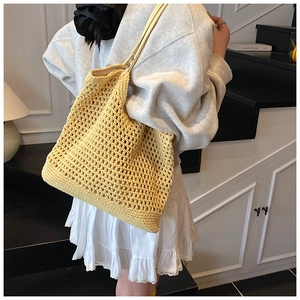 Macro detail of yellow hollow crochet woven shoulder bag with bohemian mesh pattern
