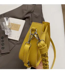 Close-up of bright yellow litchi grain shoulder bag with woven strap and silver hardware