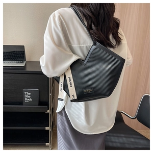 Détail du sac cabas plissé noir avec logo en métal et ruban élégant à lettres