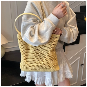 Detailed texture of lemon yellow crochet hollow knit tote bag with slender leather handles