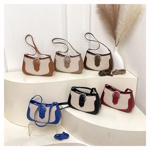 Collection of canvas shoulder bags with leather trim in six diverse colors on a white stand